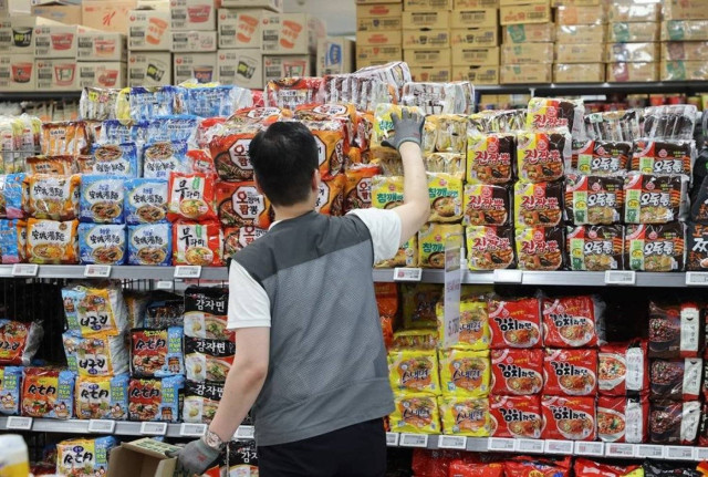 A worker at a supermarket in South Korea puts bags of instant noodles on the shelves